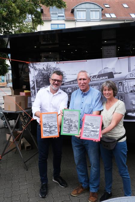 Drei Menschen präsentieren Bücher in ihren Händen